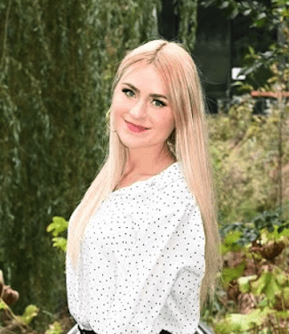 A woman standing in the grass wearing a skirt.