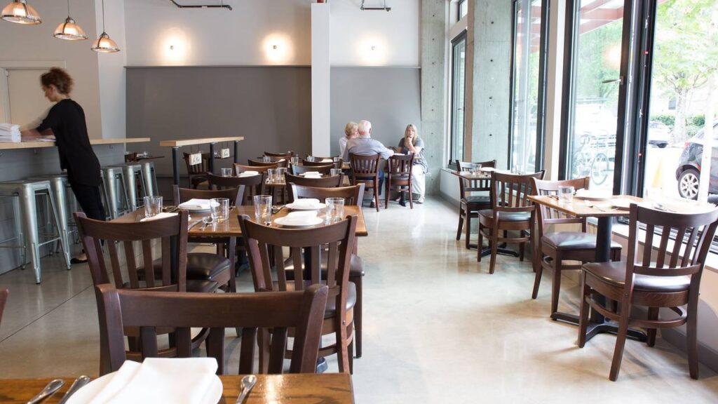 A restaurant with people sitting at tables in it.