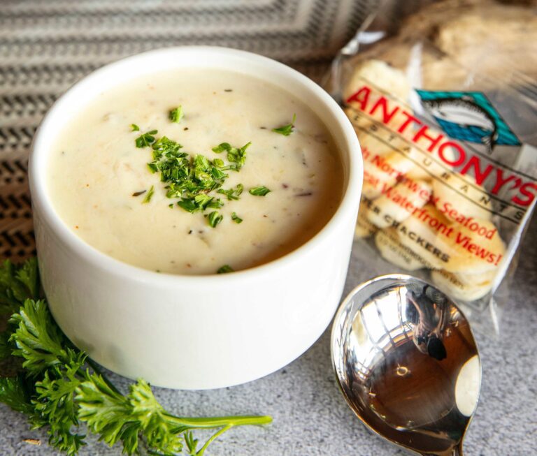 A bowl of soup with some parsley on the side