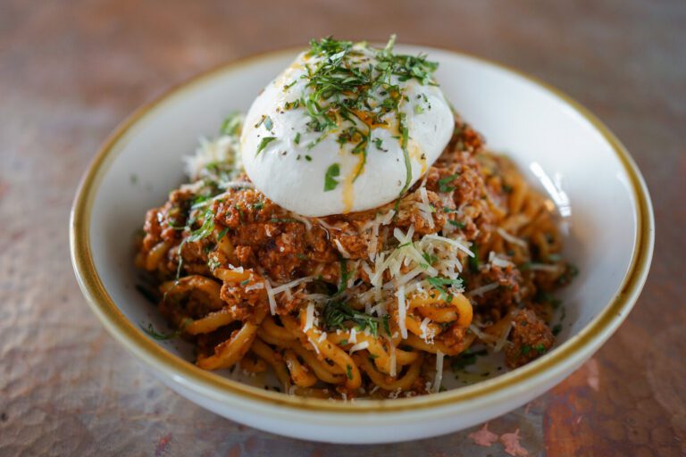 A bowl of pasta with meat and sauce.