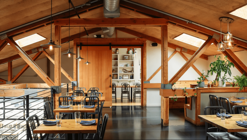 A restaurant with wooden tables and chairs in it.