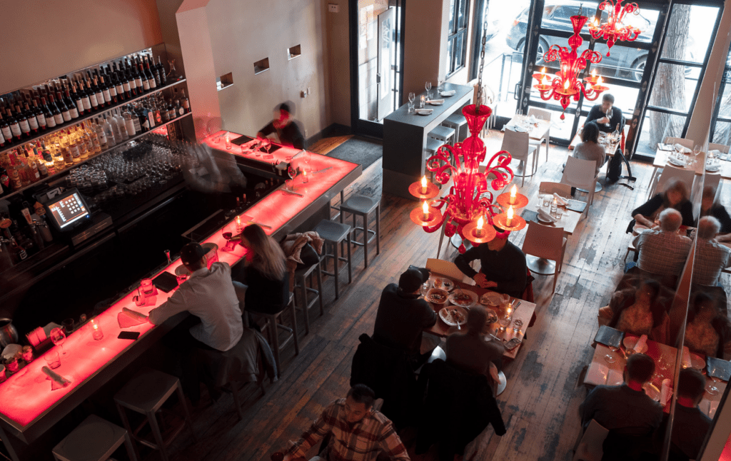 A restaurant with people sitting at tables and chairs.