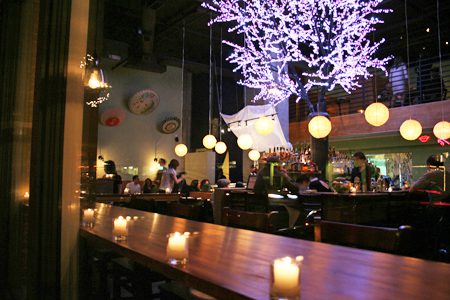 A restaurant with candles lit up in the center of it.