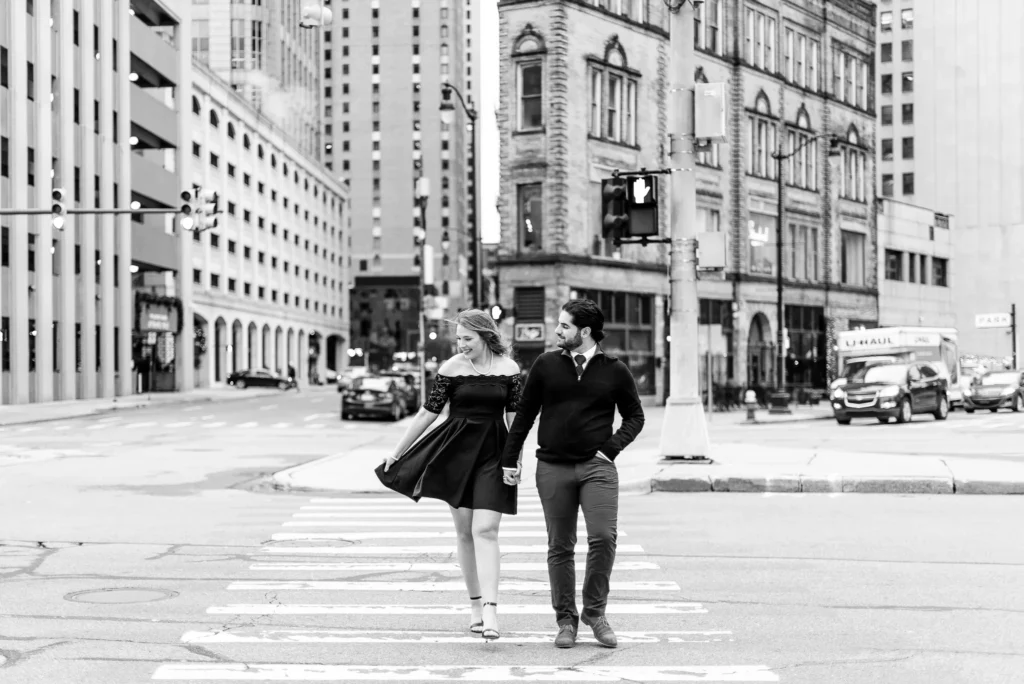 A man and woman are walking across the street.