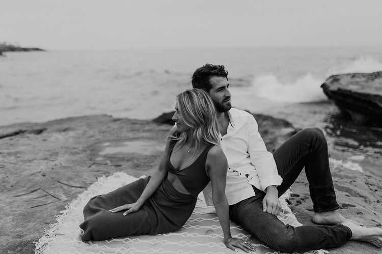 A man and woman sitting on the beach