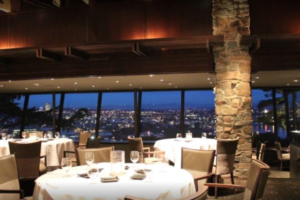 A restaurant with tables and chairs in front of the window.