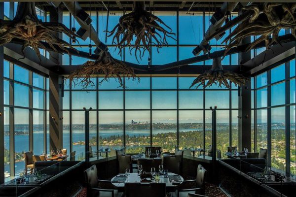 A restaurant with a view of the ocean and mountains.