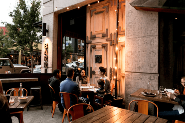 A group of people sitting at tables outside