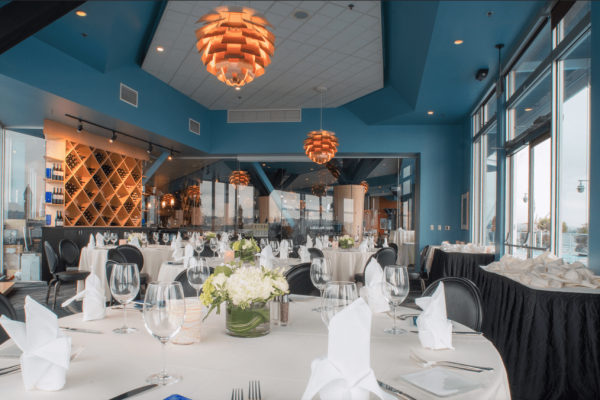 A restaurant with tables and chairs set up for dinner.